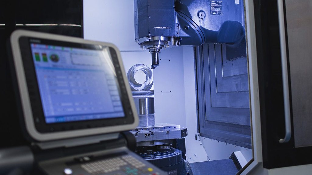 A CNC control screen beside the spindle of a machining center